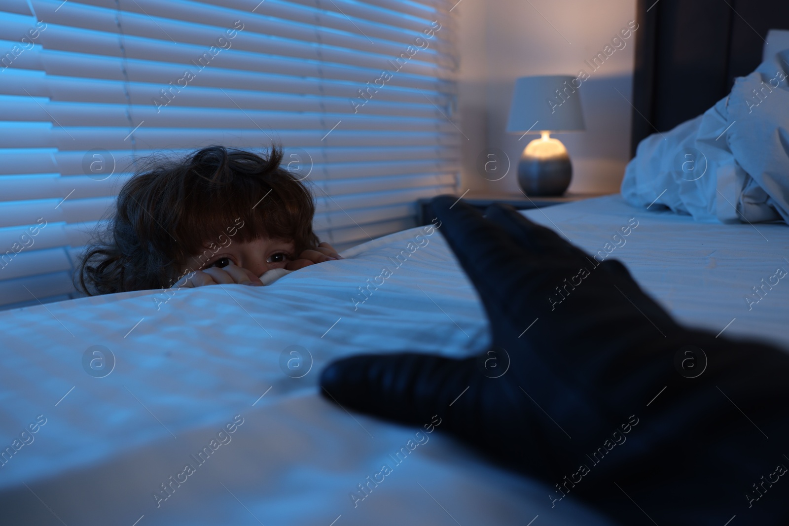 Photo of Bogeymen reaching for scared boy in bedroom at night, closeup