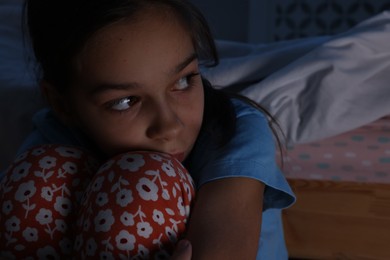 Photo of Afraid girl near bed in her room at night