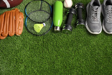 Photo of Different sports equipment on artificial grass, flat lay. Space for text