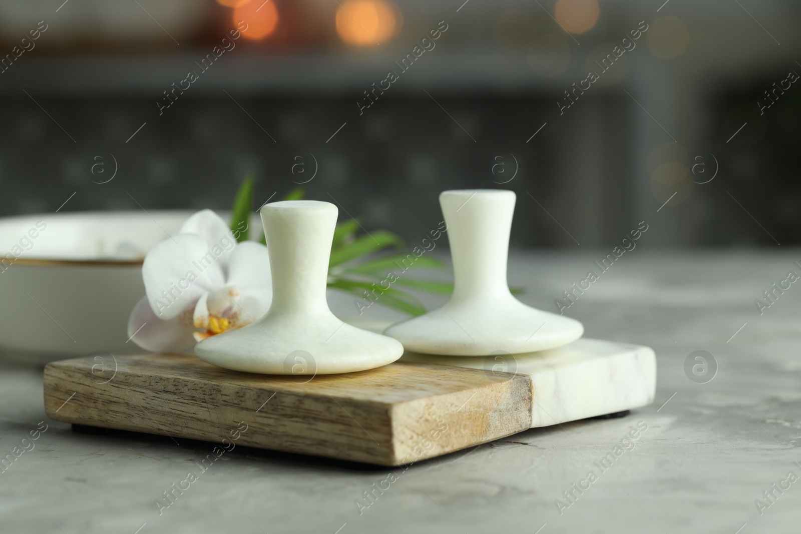 Photo of Spa stones and orchid flower on grey table, closeup