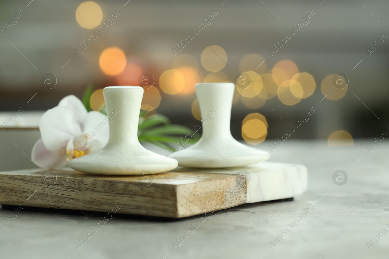 Photo of Spa stones and orchid flower on grey table, closeup