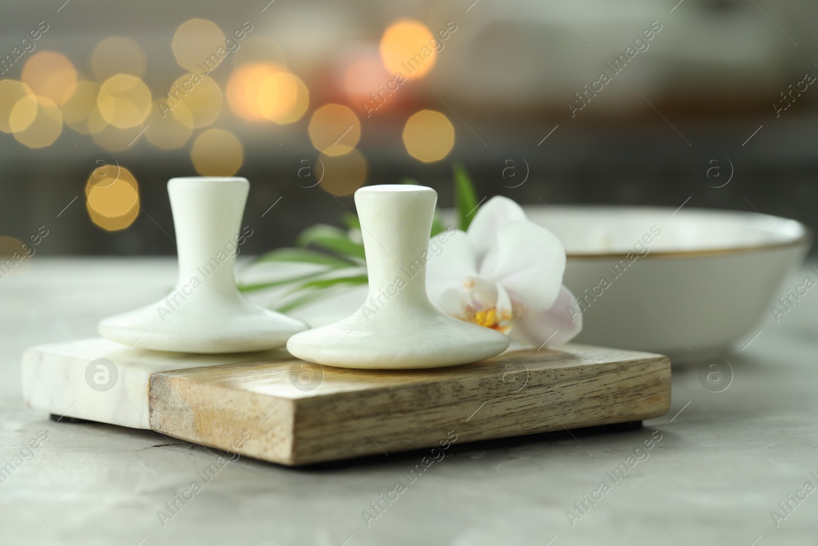 Photo of Spa stones and orchid flower on grey table, closeup