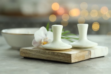 Photo of Spa stones and orchid flower on grey table, closeup