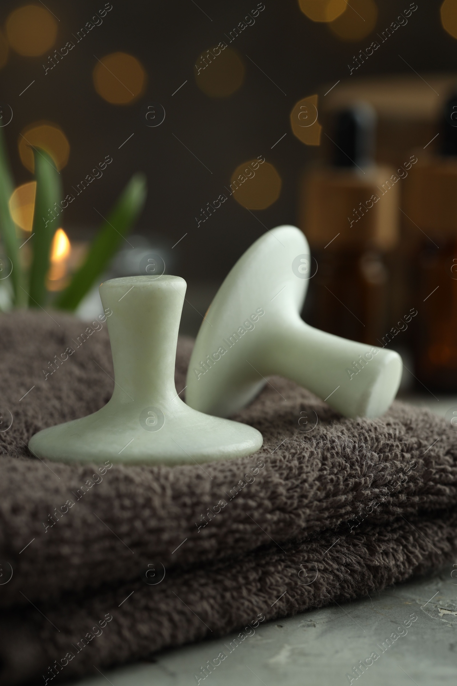 Photo of Spa stones and towel on grey table, closeup