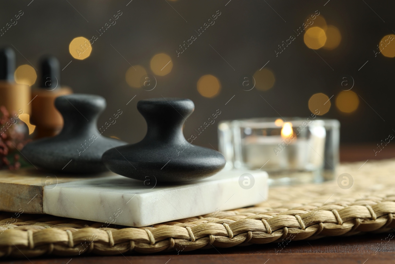 Photo of Spa stones and burning candle on table, closeup