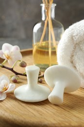 Photo of Spa stones, orchid flowers, towel and reed diffuser on wooden tray, closeup