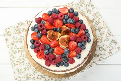 Photo of Delicious chocolate sponge cake with berries on white wooden table, top view