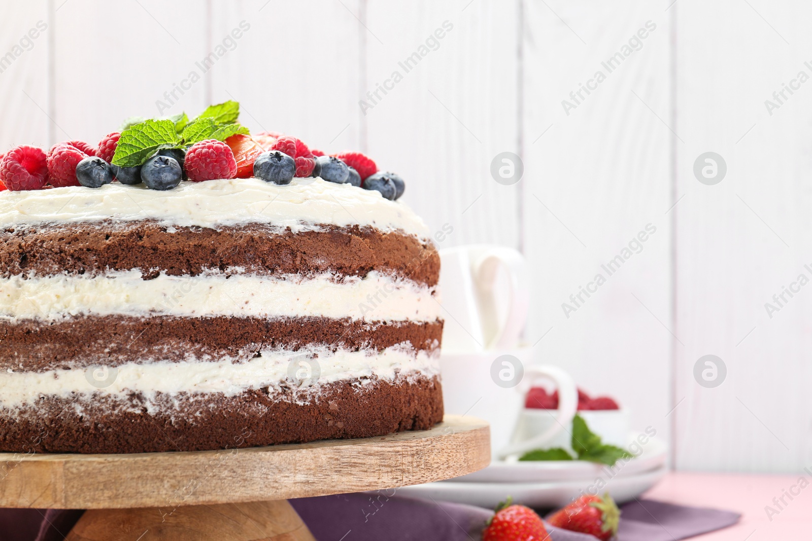 Photo of Delicious chocolate sponge cake with berries on table, closeup. Space for text