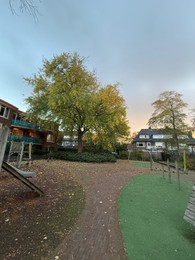 Photo of Beautiful tree and dry fallen leaves in residential area on autumn day