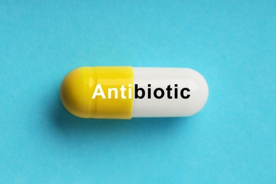 Image of Capsule with word Antibiotic on light blue background, top view