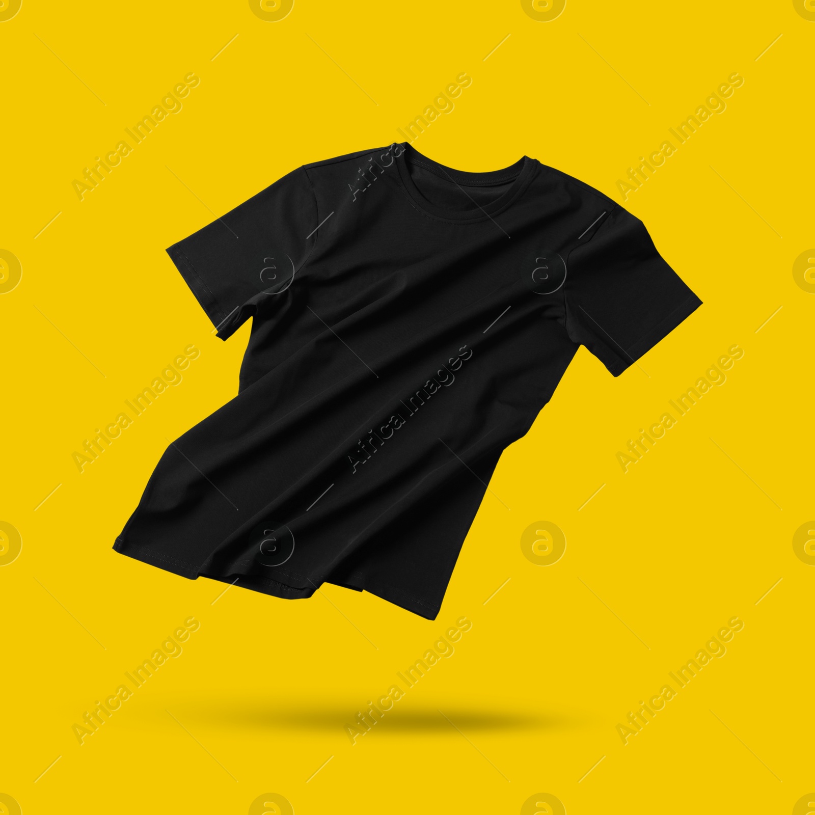 Image of Black t-shirt in air on golden background