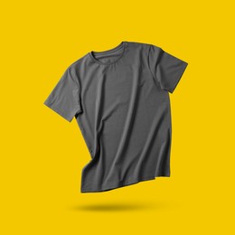 Image of Grey t-shirt in air on golden background