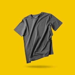 Image of Grey t-shirt in air on golden background