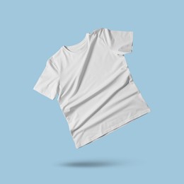 Image of White t-shirt in air on light blue background