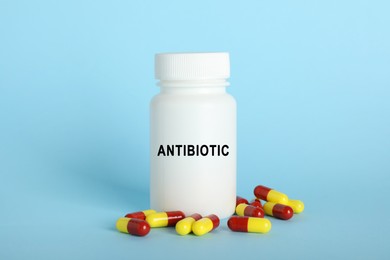 Image of Bottle of antibiotic pills on light blue background