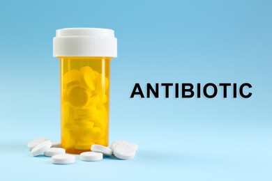 Image of Bottle of antibiotic pills on light blue background