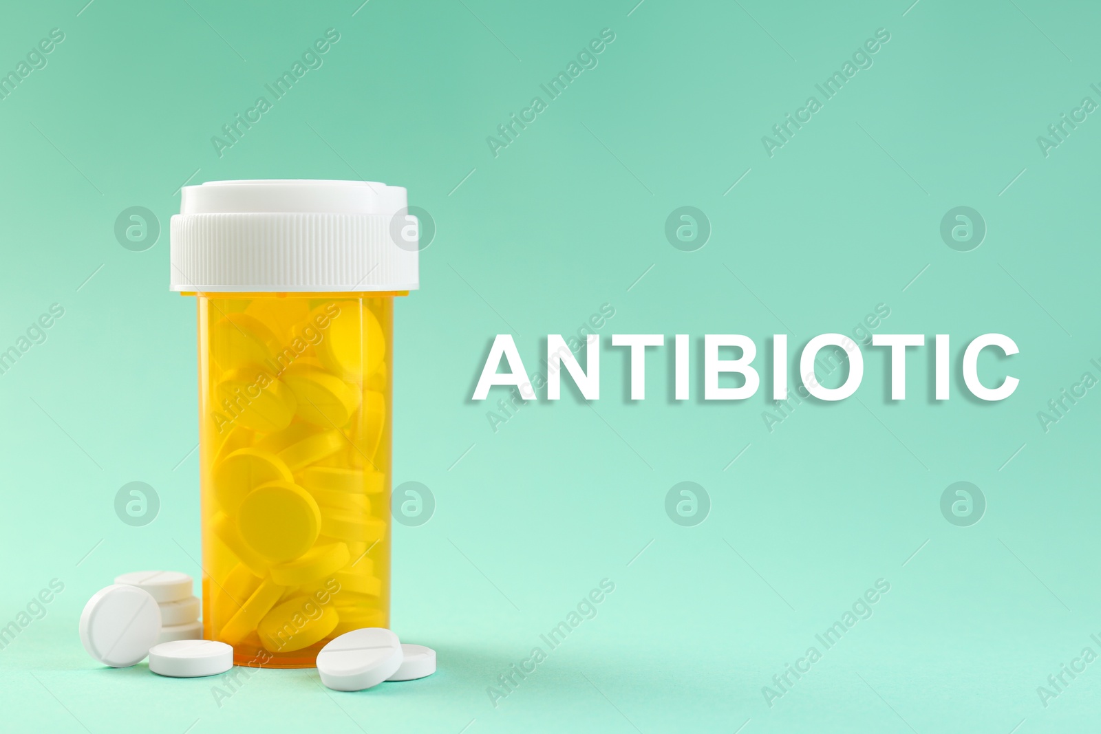 Image of Bottle of antibiotic pills on aquamarine color background