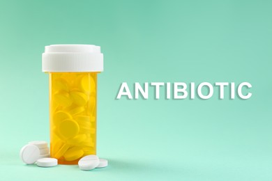 Image of Bottle of antibiotic pills on aquamarine color background