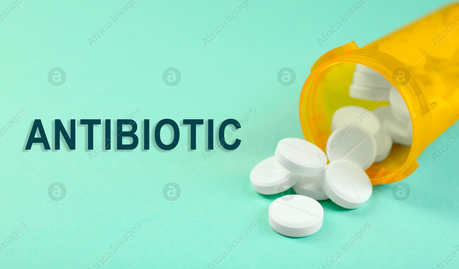 Image of Bottle of antibiotic pills on aquamarine background, closeup