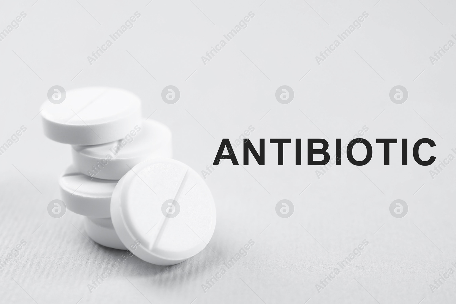 Image of Word Antibiotic and pills on grey background, closeup