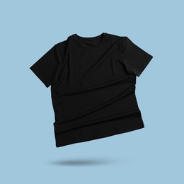 Image of Black t-shirt in air on light blue background