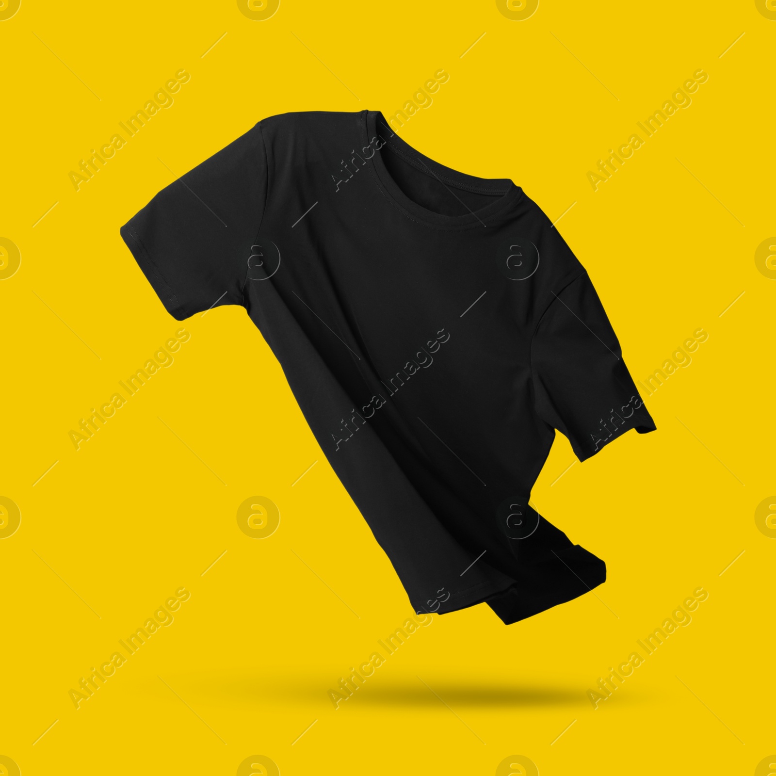 Image of Black t-shirt in air on golden background