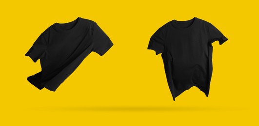 Image of Black t-shirts in air on golden background