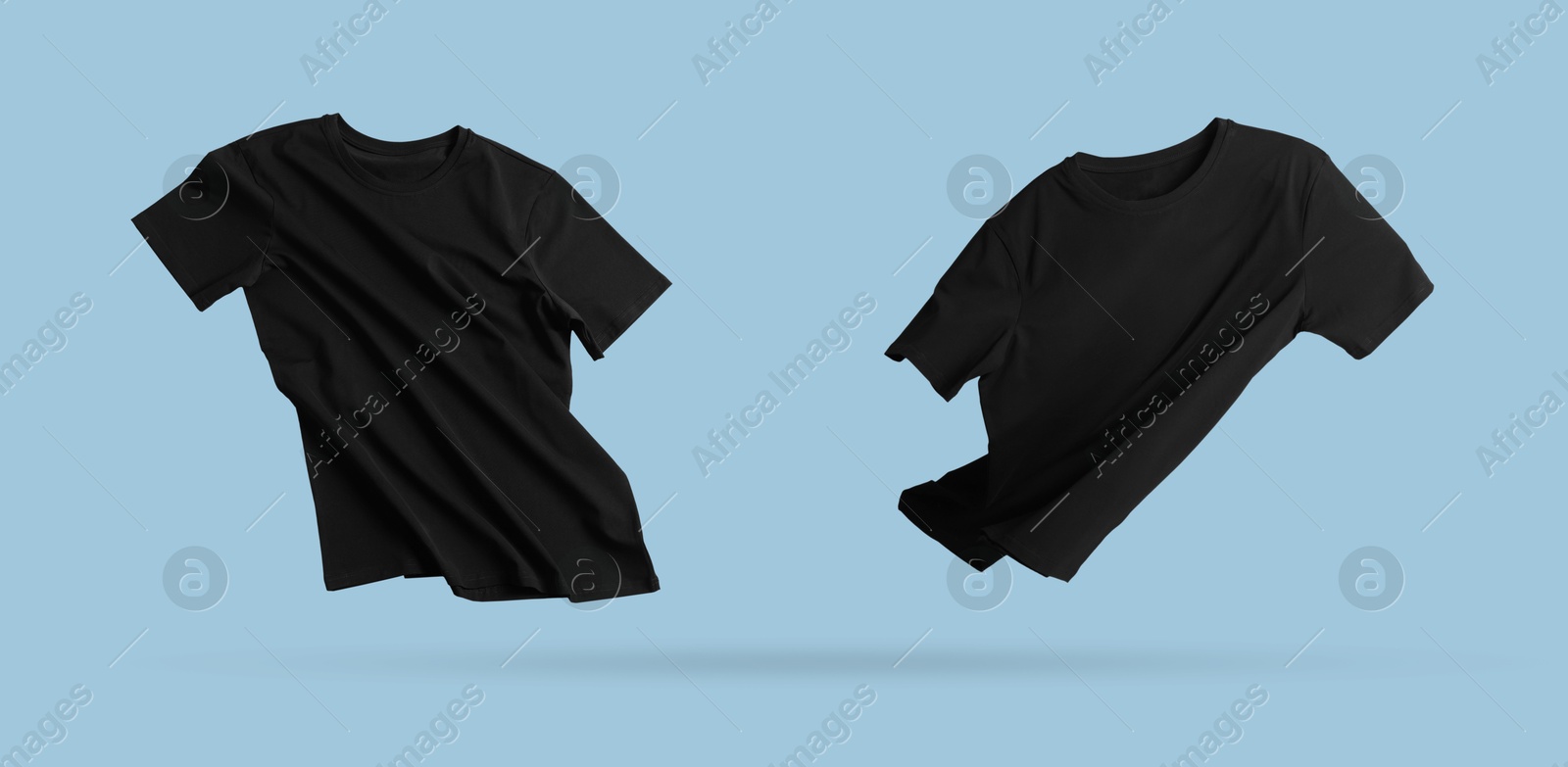 Image of Black t-shirts in air on light blue background