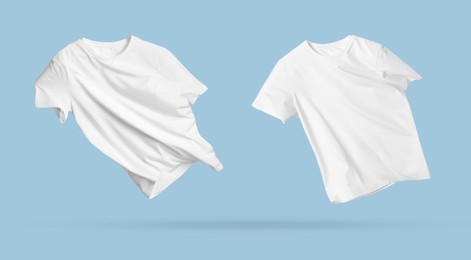 Image of White t-shirts in air on light blue background