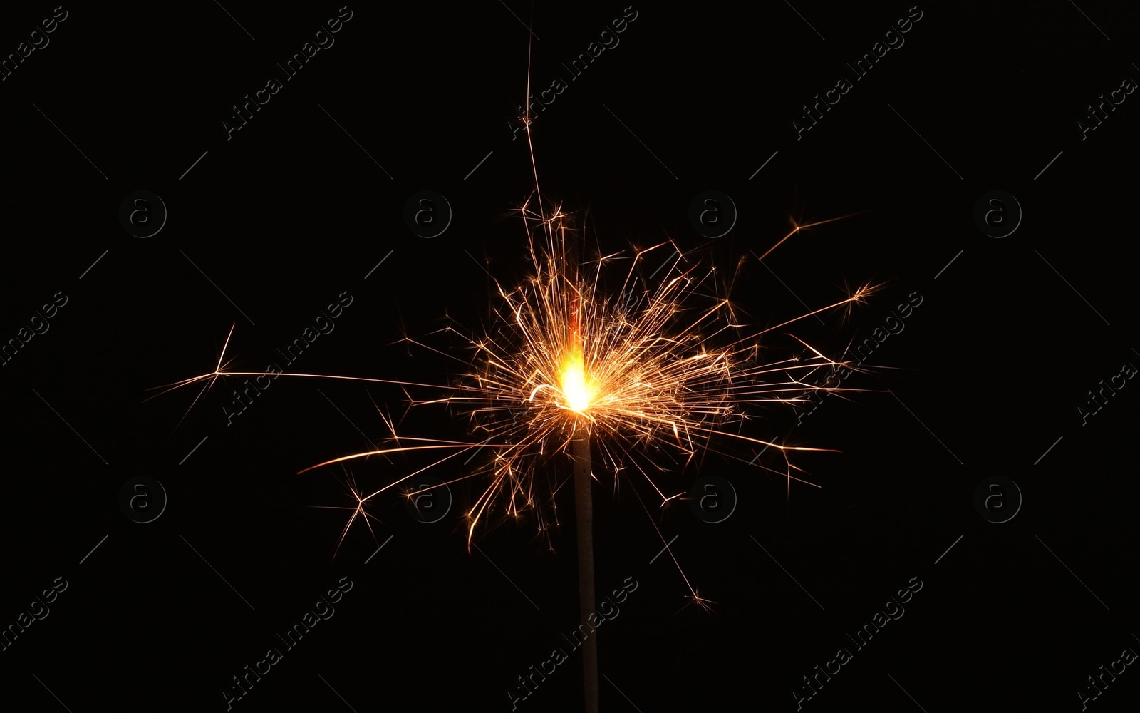 Photo of Burning sparkler stick on black background, space for text