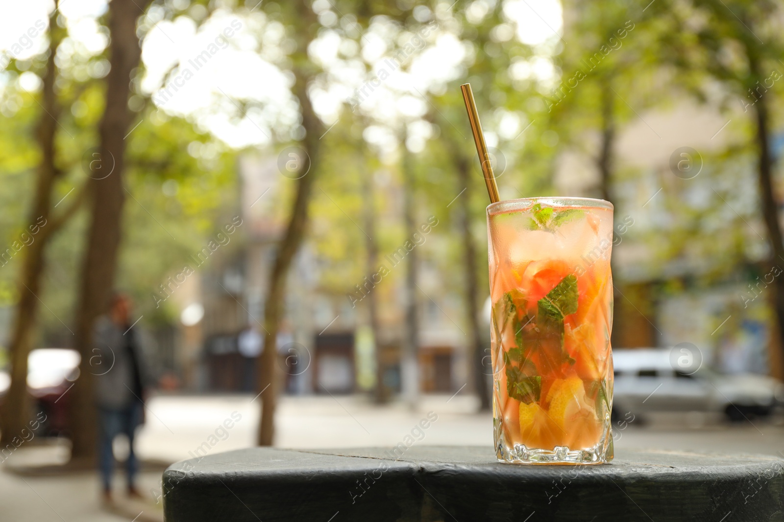 Photo of Glass of tasty refreshing drink and straw on table, space for text