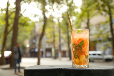 Photo of Glass of tasty refreshing drink and straw on table, space for text