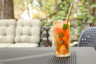 Photo of Glass of tasty refreshing drink and straw on table in outdoor cafe. Space for text