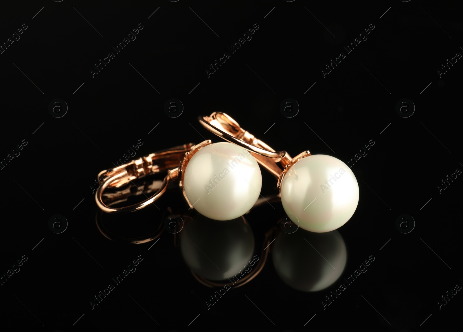 Photo of Beautiful bijouterie. Stylish earrings on black background