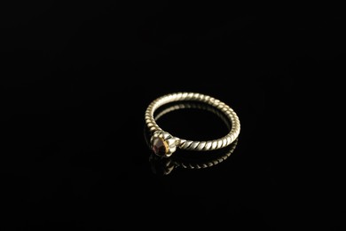 Photo of Beautiful bijouterie. Stylish ring on black background