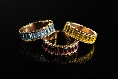 Photo of Beautiful bijouterie. Stylish rings on black background