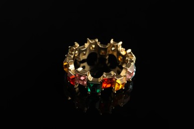 Photo of Beautiful bijouterie. Stylish ring on black background