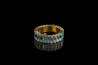 Photo of Beautiful bijouterie. Stylish ring on black background