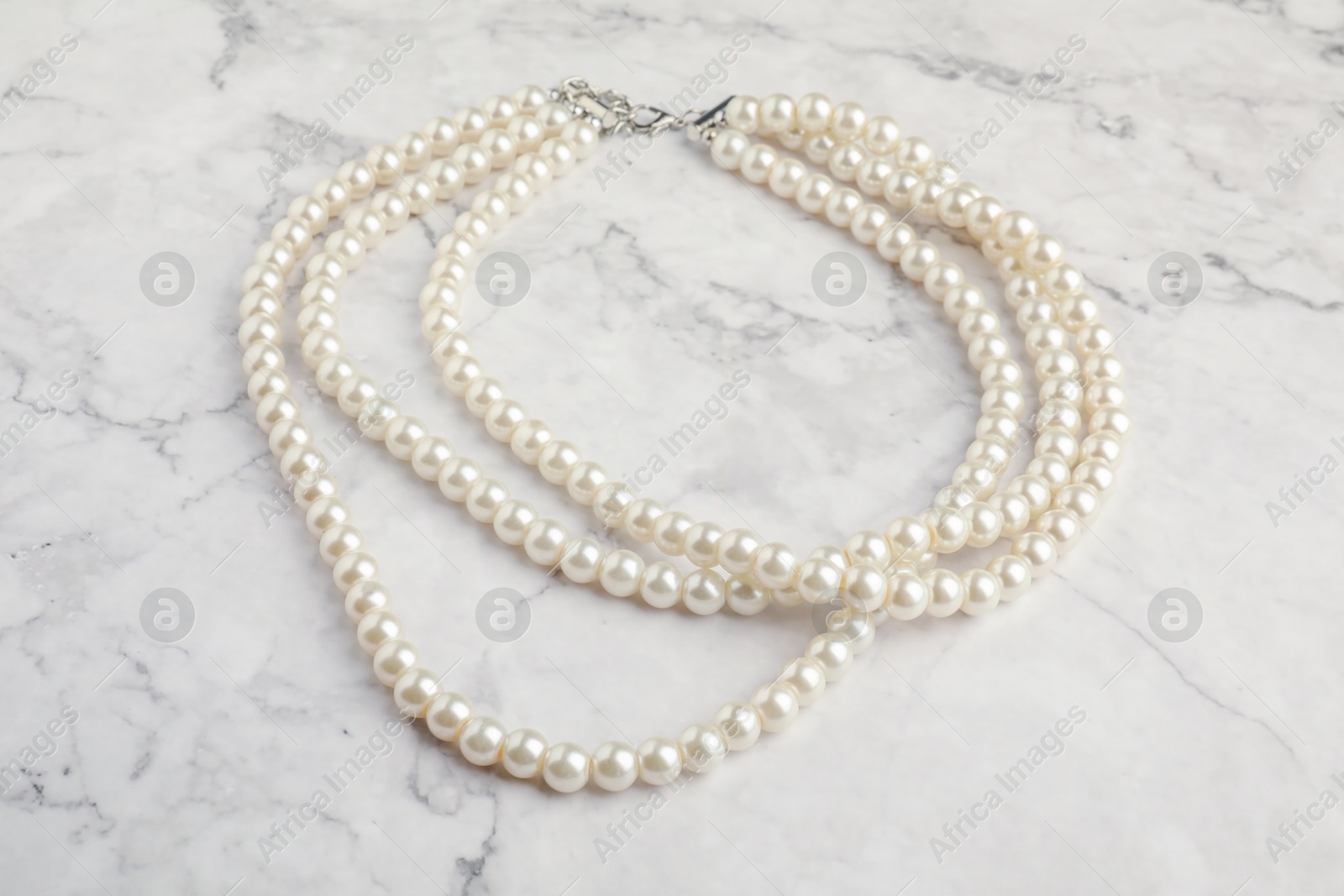 Photo of Beautiful bijouterie. Elegant necklace on white marble table