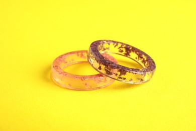 Beautiful bijouterie. Elegant rings on yellow background, closeup