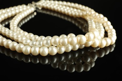 Beautiful bijouterie. Elegant necklace on black mirror surface, closeup