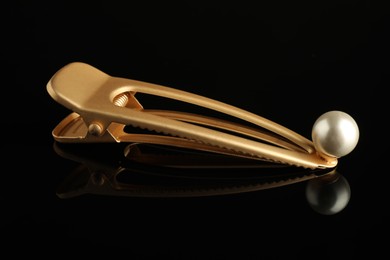 Beautiful bijouterie. Elegant hair clip on black mirror surface, closeup