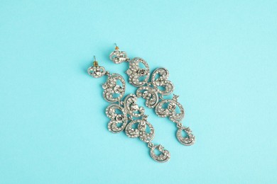 Beautiful bijouterie. Stylish earrings on light blue background, top view