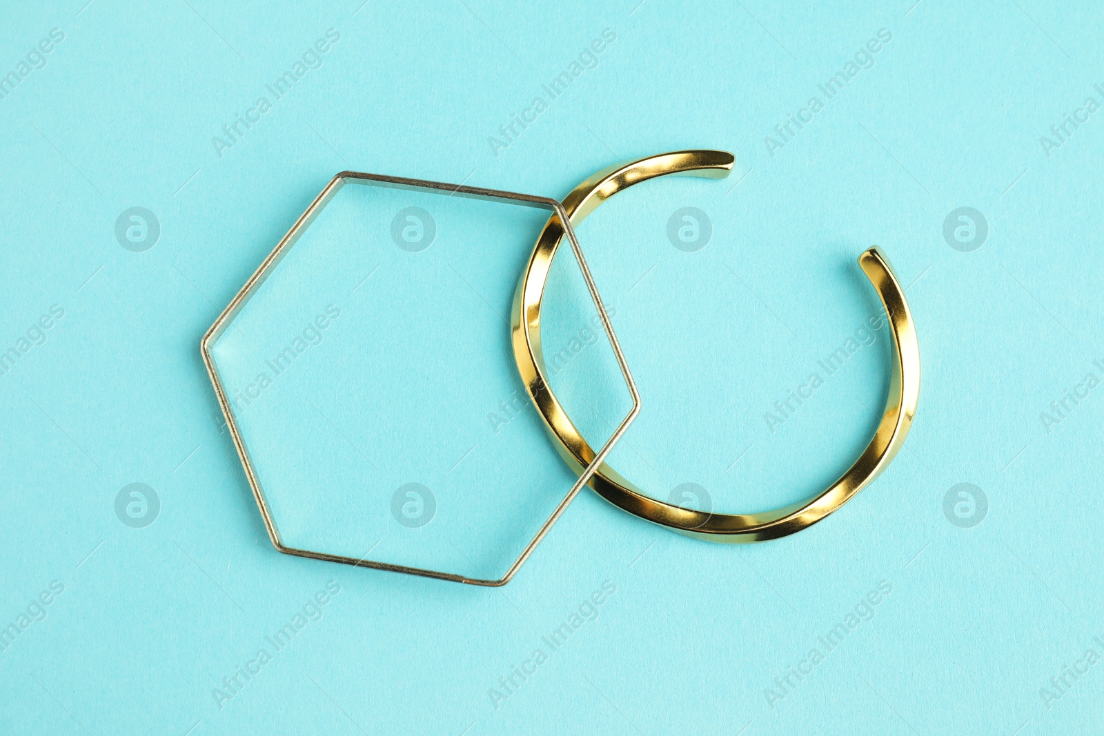 Photo of Beautiful bijouterie. Stylish bracelets on light blue background, top view