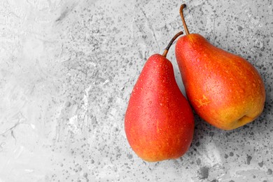 Photo of Two ripe juicy pears on grey table, top view. Space for text