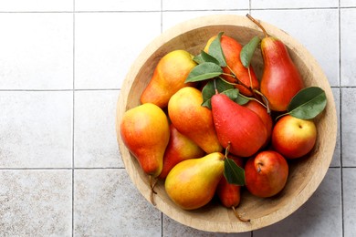 Photo of Ripe juicy pears on light tiled table, top view