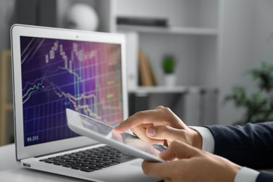 Photo of Businesswoman using tablet at white table indoors, closeup. Modern technology