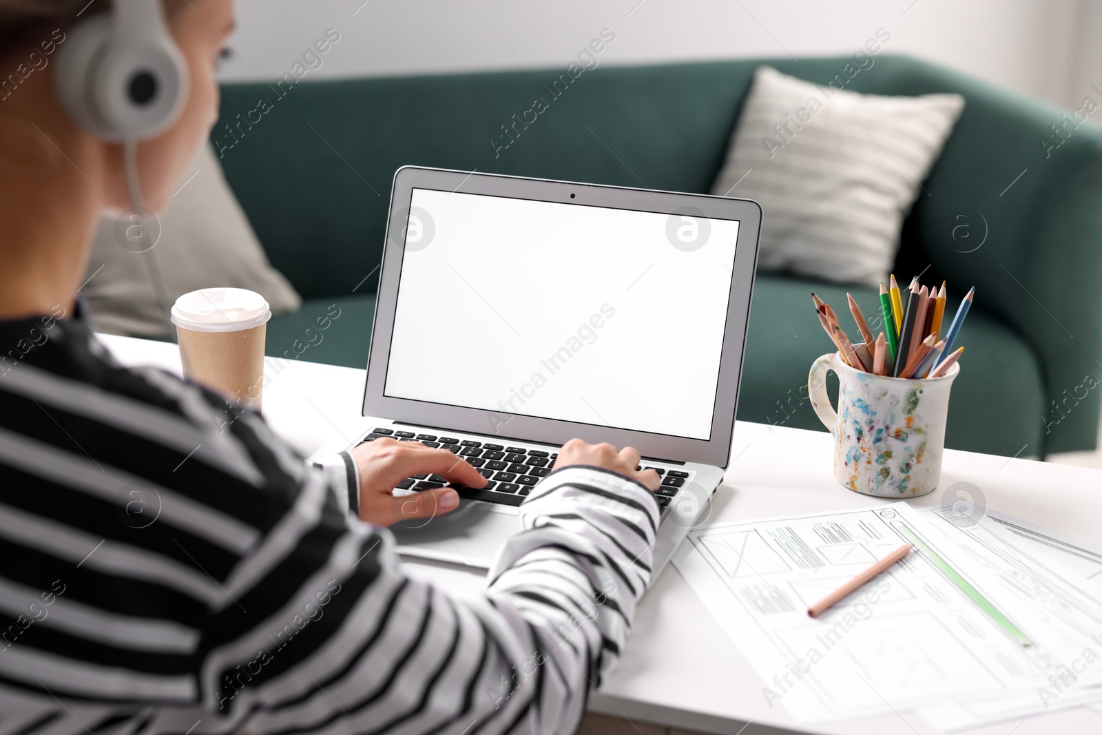 Photo of Woman working with laptop at table in office, closeup. Mockup for design