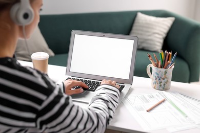 Photo of Woman working with laptop at table in office, closeup. Mockup for design