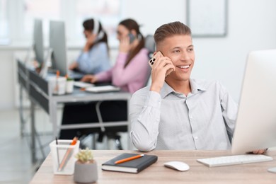 Salesman talking on phone at desk in office